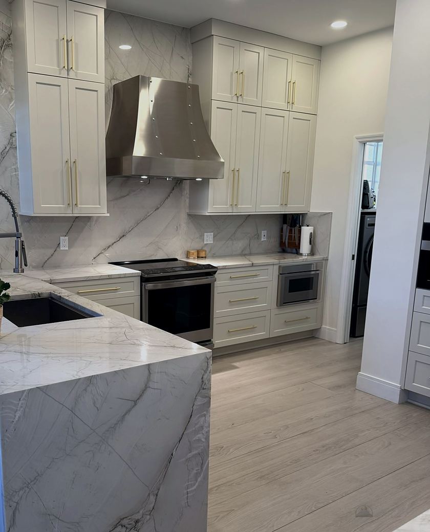 Kitchen with a full-height stone backsplash and waterfall island