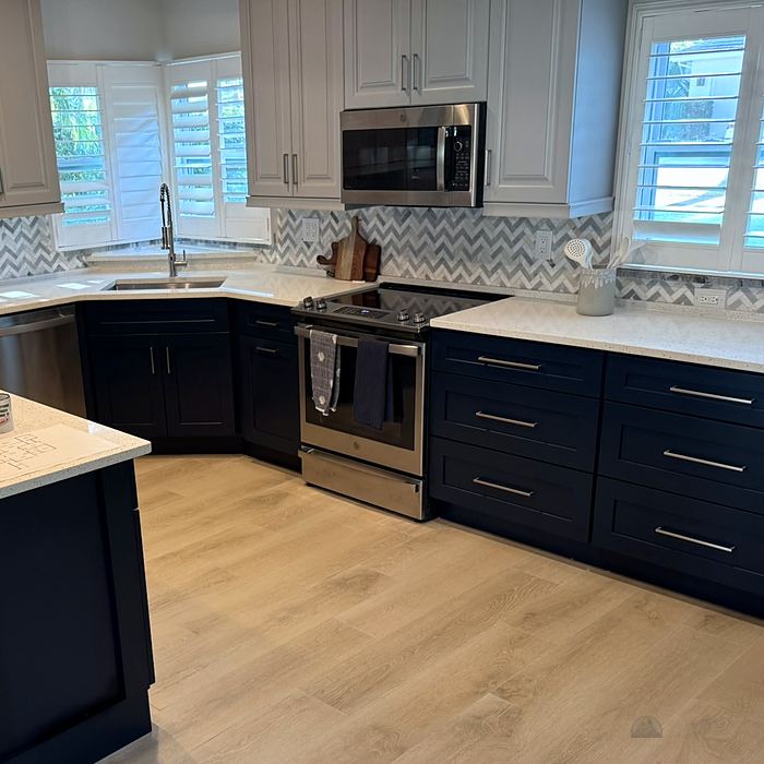 Compact kitchen with dark blue cabinets and stone counters