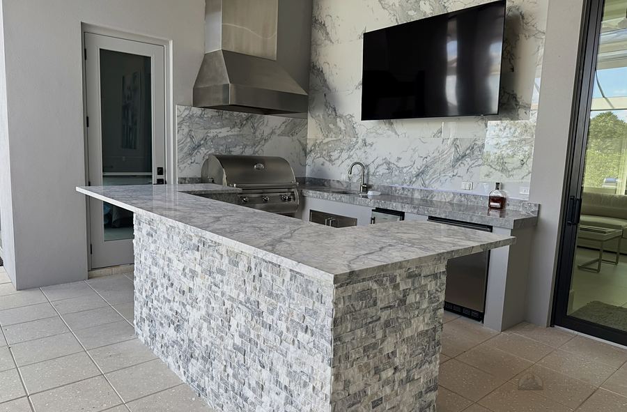 Covered outdoor kitchen with grill and stone island