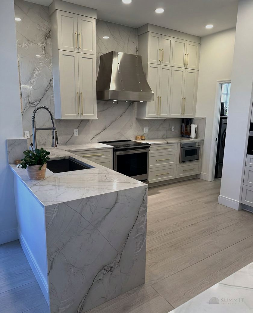 Marble waterfall island in a finished kitchen